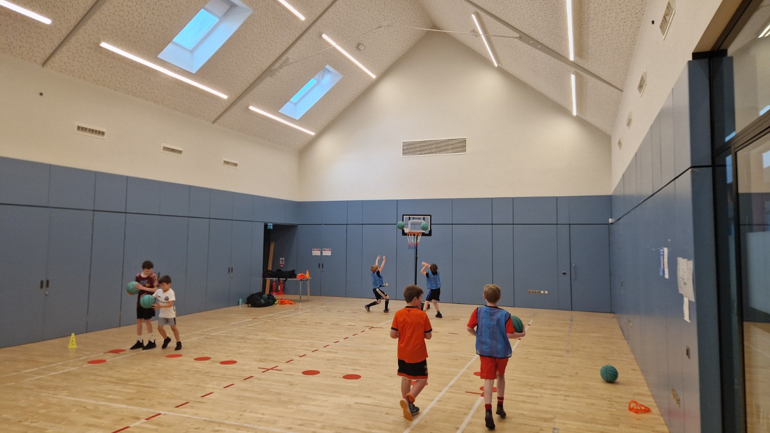 Young players spread across the court during an active basketball session