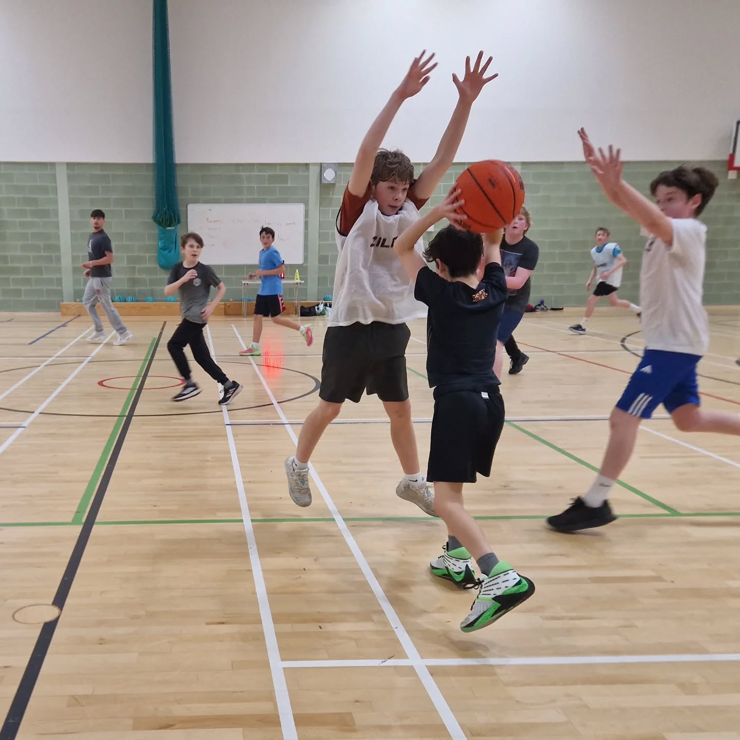 Young basketball players competing for space during a live game activity
