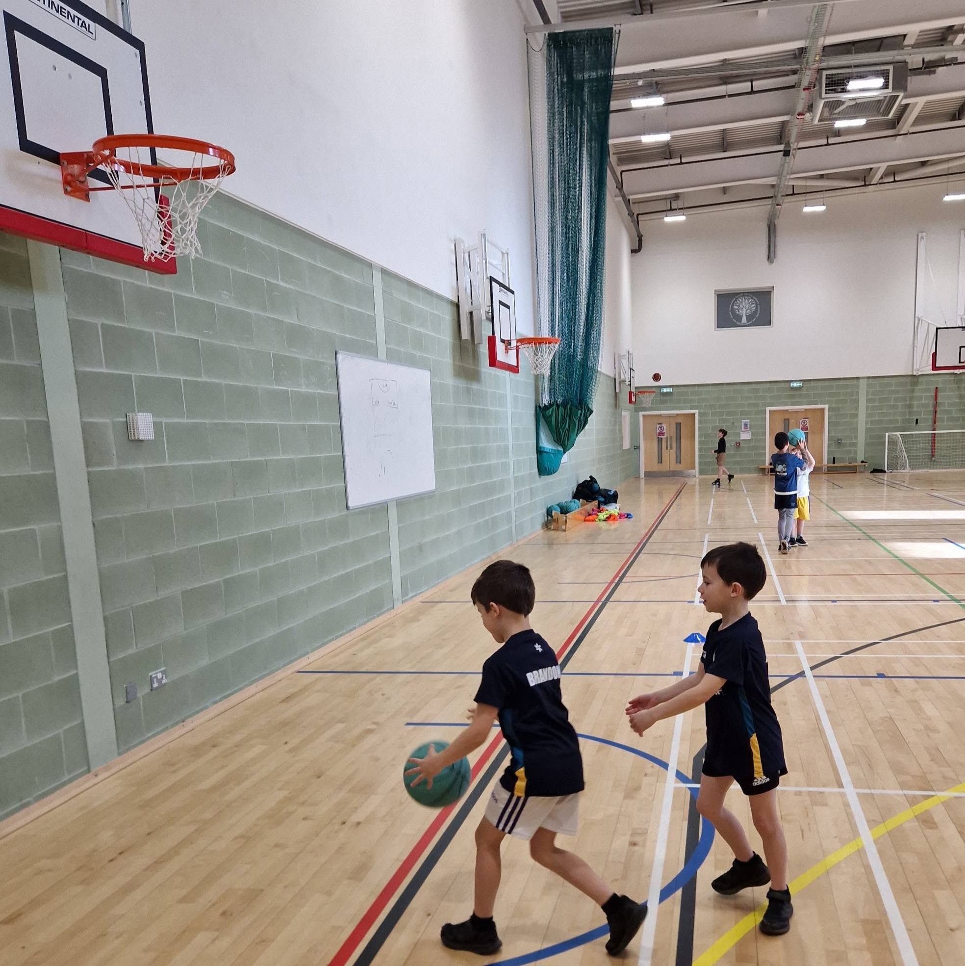Young North East Fife Basketball players practising near the basket