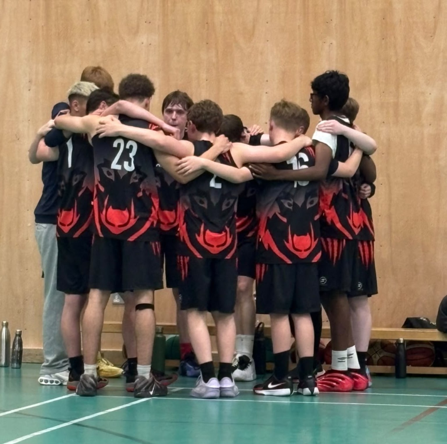 A youth basketball team standing together in a pre-game huddle