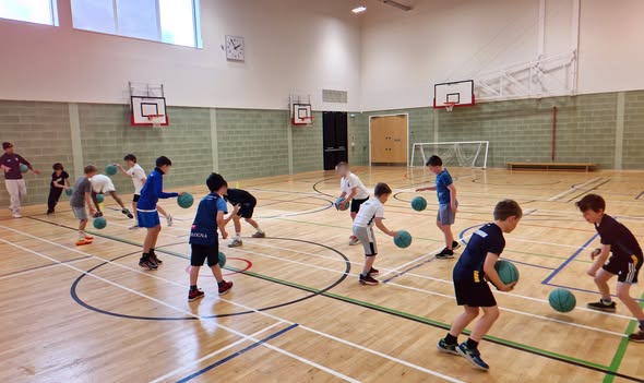 Young NEF Basketball players practising ball-handling during a club session